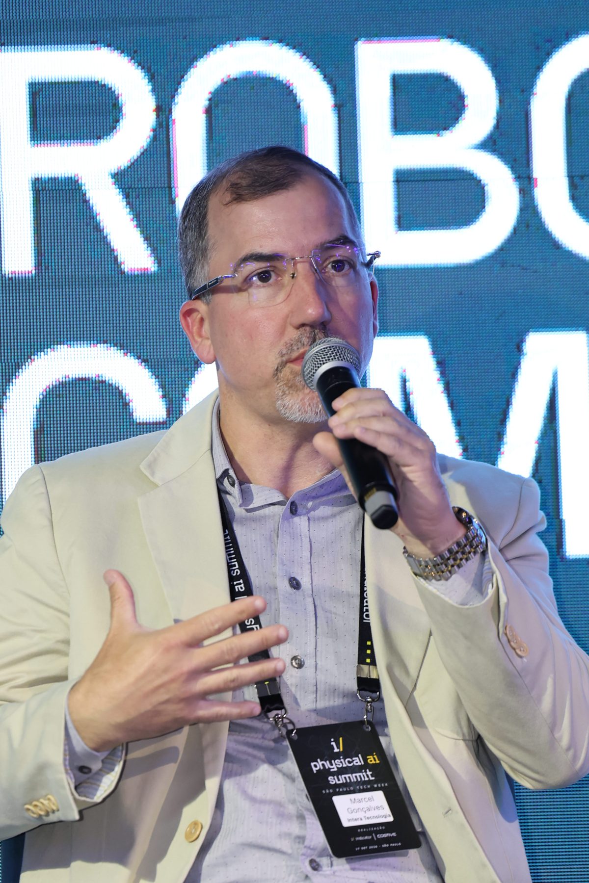 Marcel Gonçalves diante do telão “Robots are Coming to Brazil”